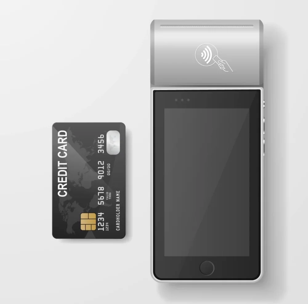 Black credit card beside a modern payment terminal